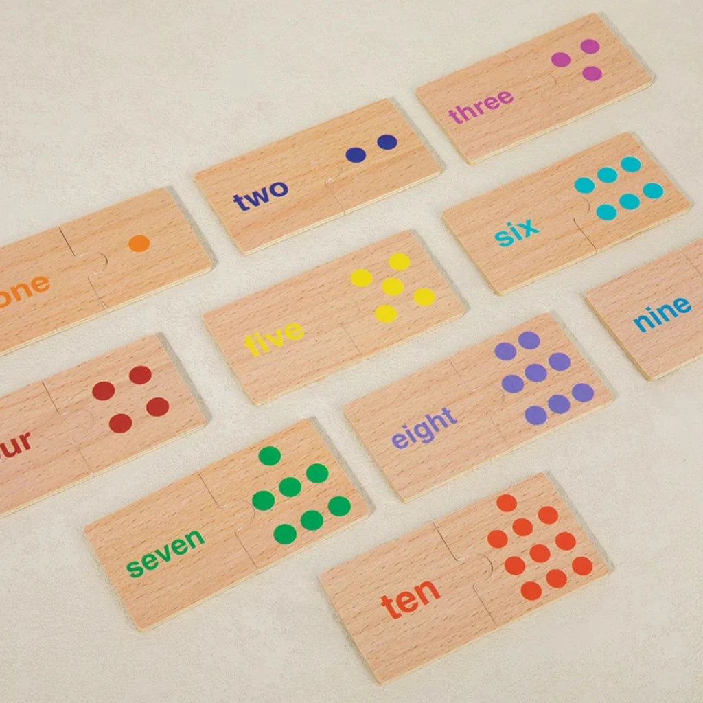 Full Montessori number matching puzzle setup with open box, animal-themed and dot-matching wooden pieces neatly arranged on table.