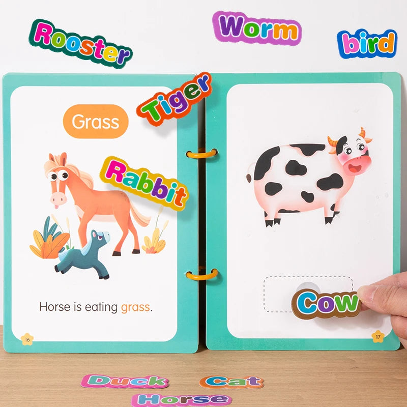 Green animal book open to cow/horse pages with colourful word stickers being matched to blank spaces.