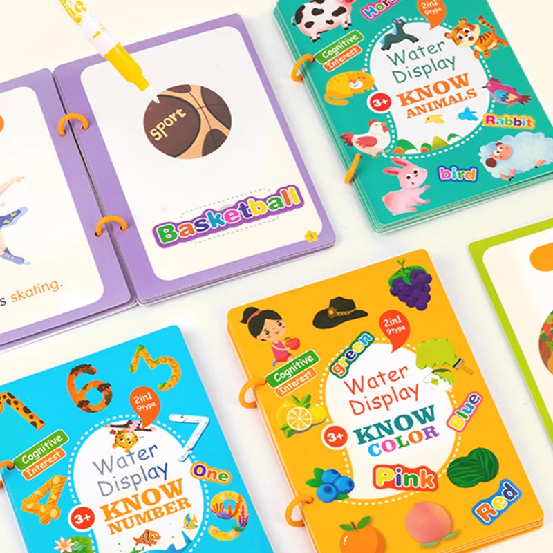 Flat-lay of several Water Display Magic Books (numbers, animals, colors, items) opened on a table with stickers and pen.